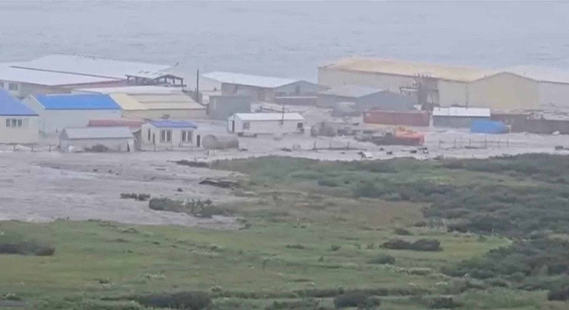 Ondas de tsunami passam por um prédio localizado perto da costa, após um forte terremoto atingir a costa da Península de Kamchatka, na Rússia