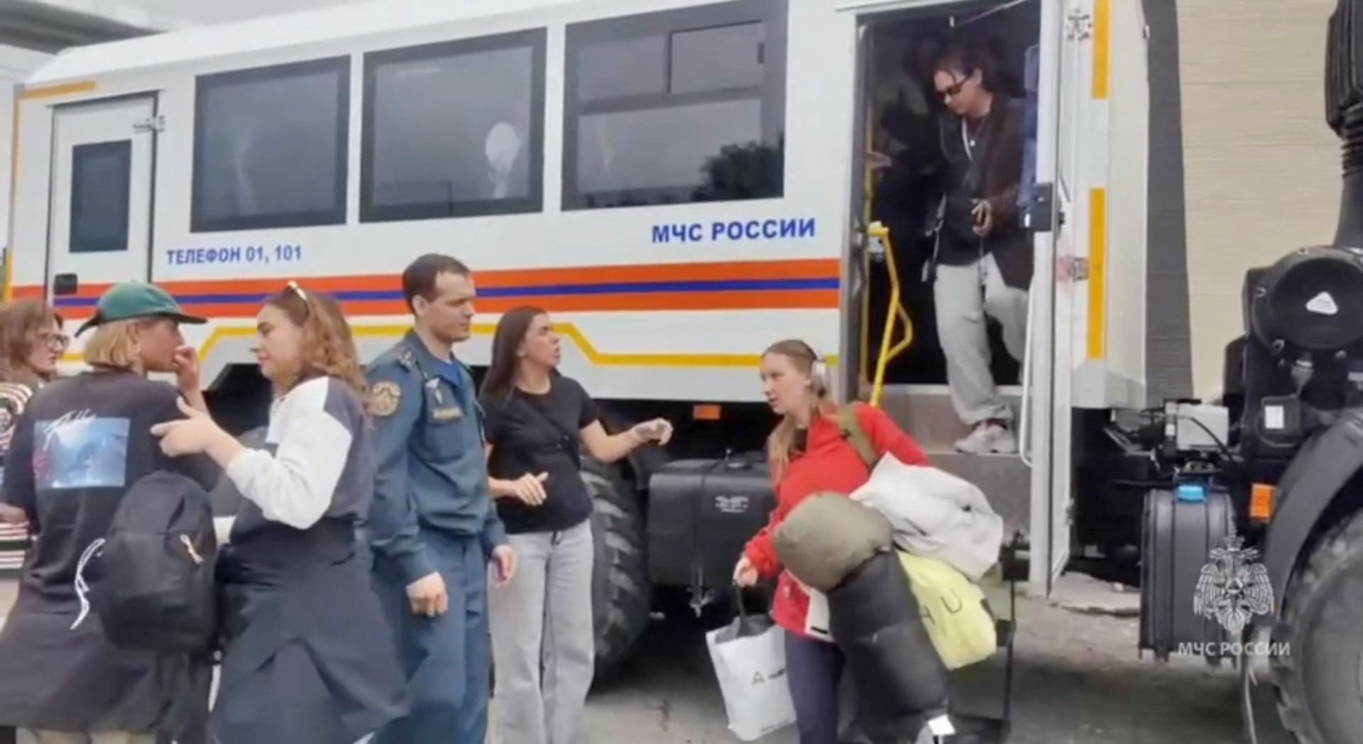 Pessoas saem de um ônibus enquanto equipes de resgate os realocam para uma área segura devido à ameaça de tsunami após um terremoto, na região de Kamchatka, na Rússia